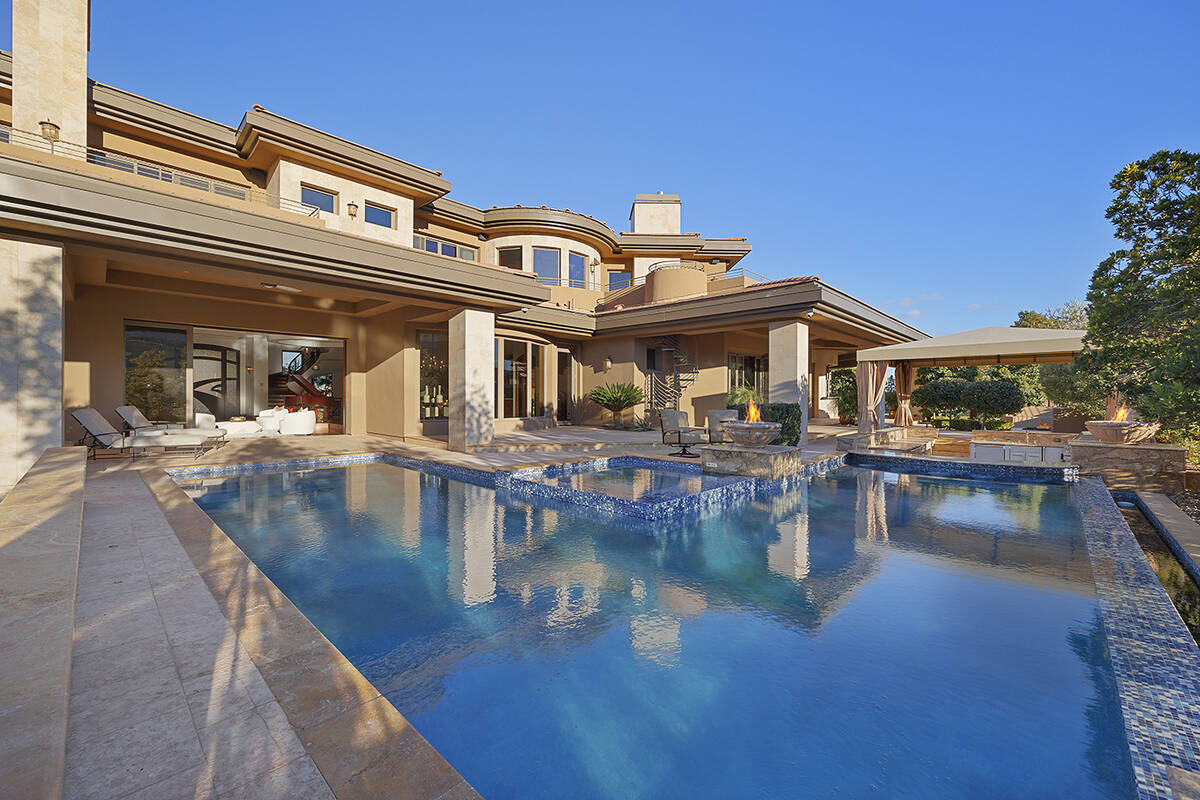 The grounds offer a swimming pool with fire features, an elevated spa, a sunken outdoor kitchen ...