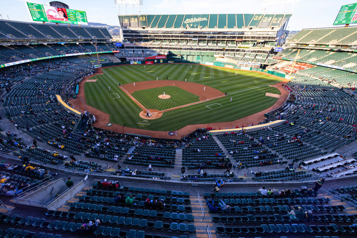 Fans watch a baseball game between the A’s and the Cincinnati Reds at the at Oakland Col ...