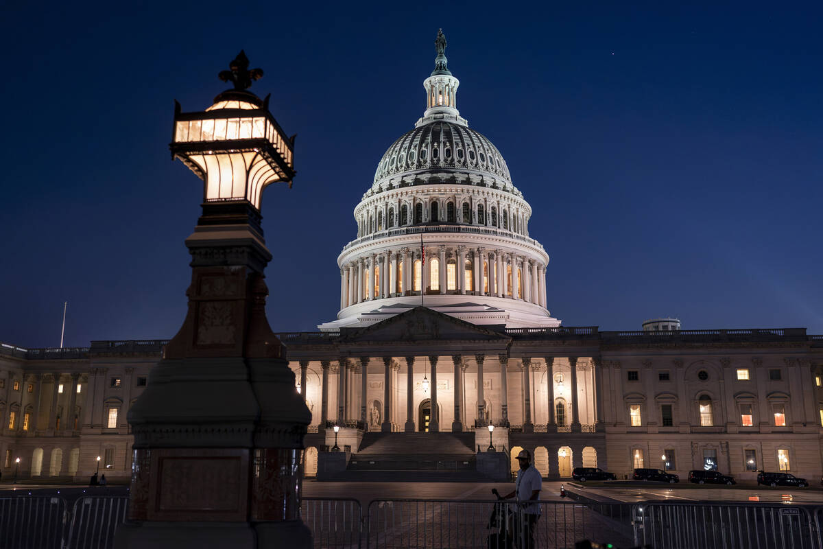 Days away from a default crisis, the Capitol is illuminated as the Senate works into the night ...