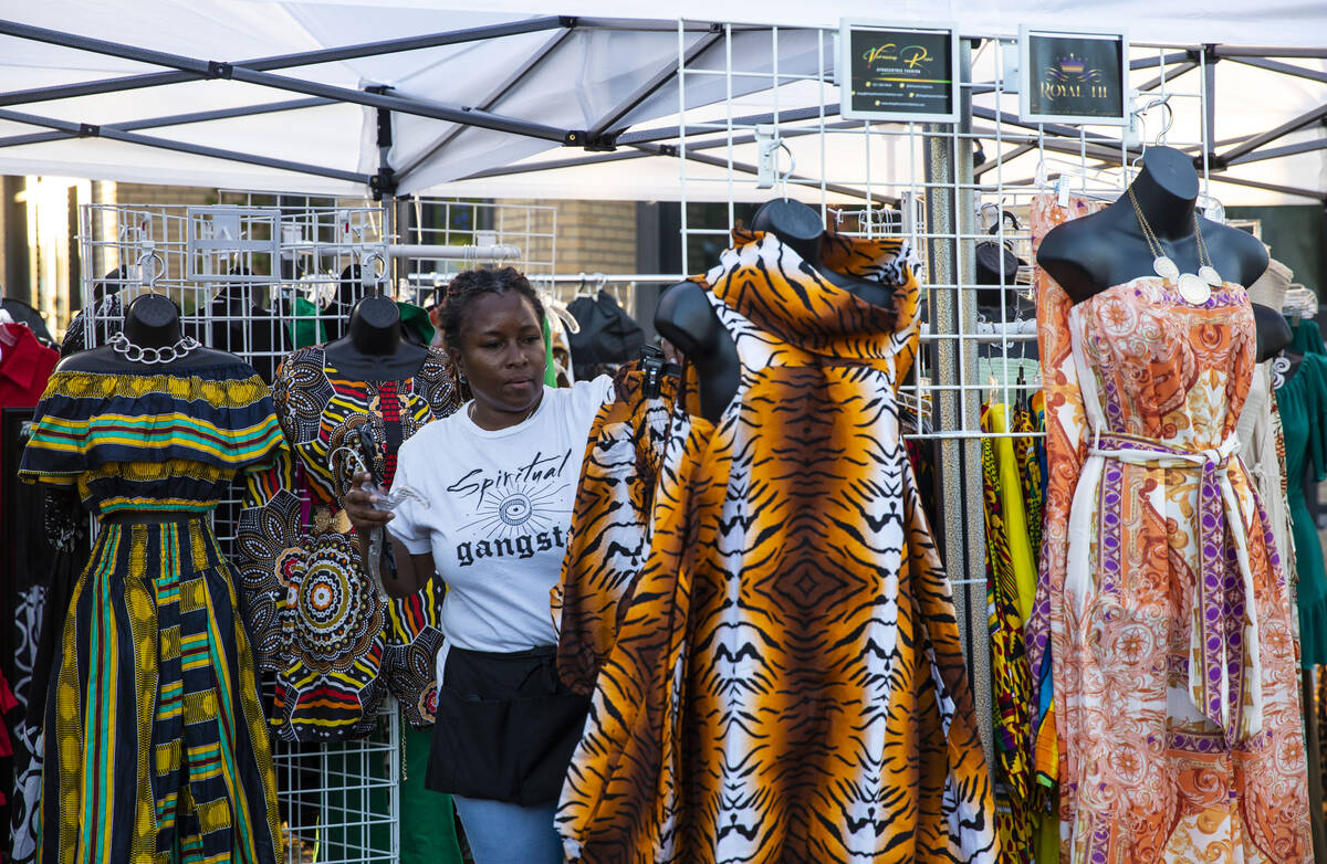 Veronica Howard organizes clothing at her afrocentric fashion booth at the First Friday art and ...