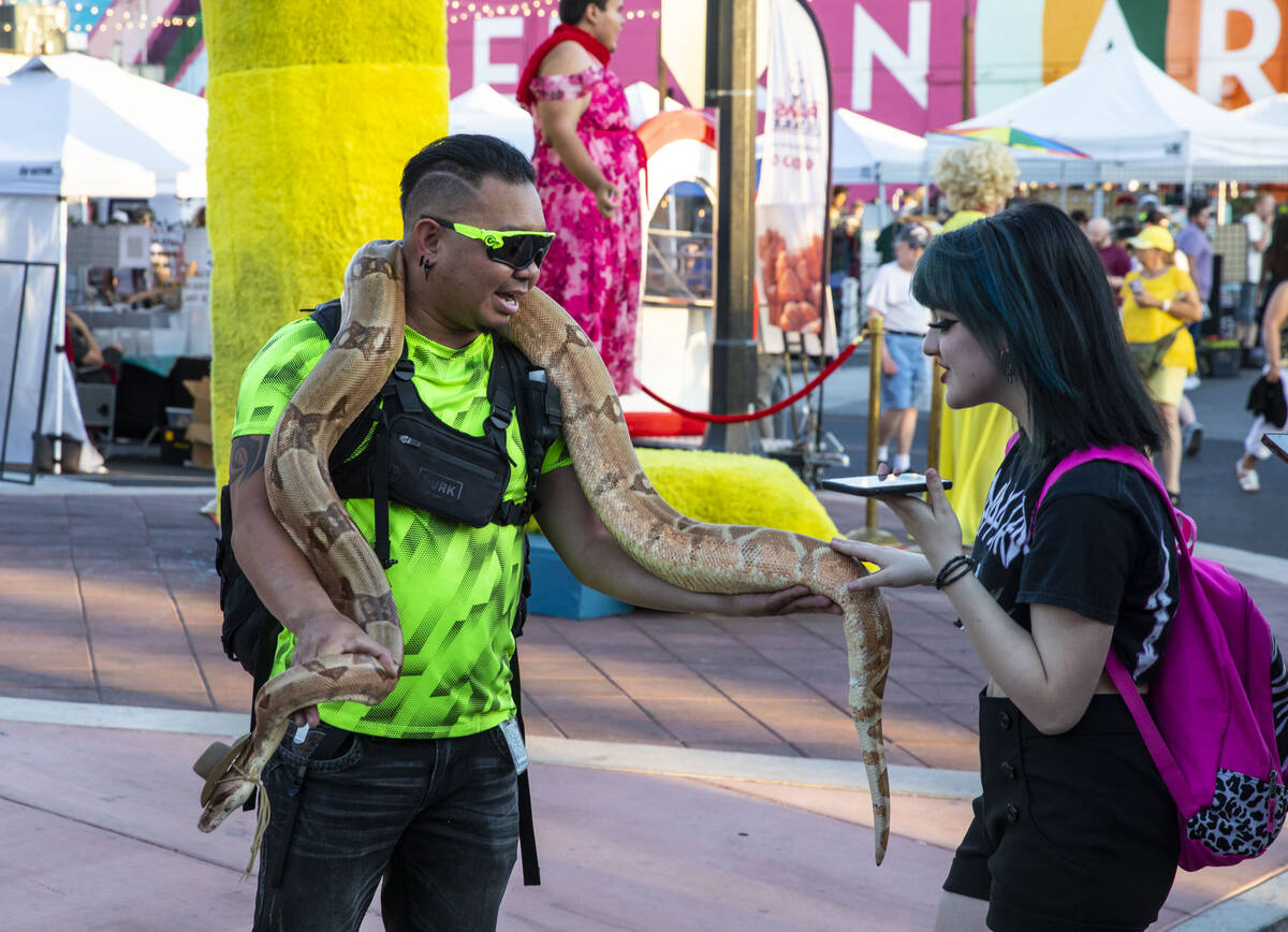 Josh Gamboa, left, lets Sophie Papadopoulos pet Salmon, his Columbian red tail boa, at the Firs ...