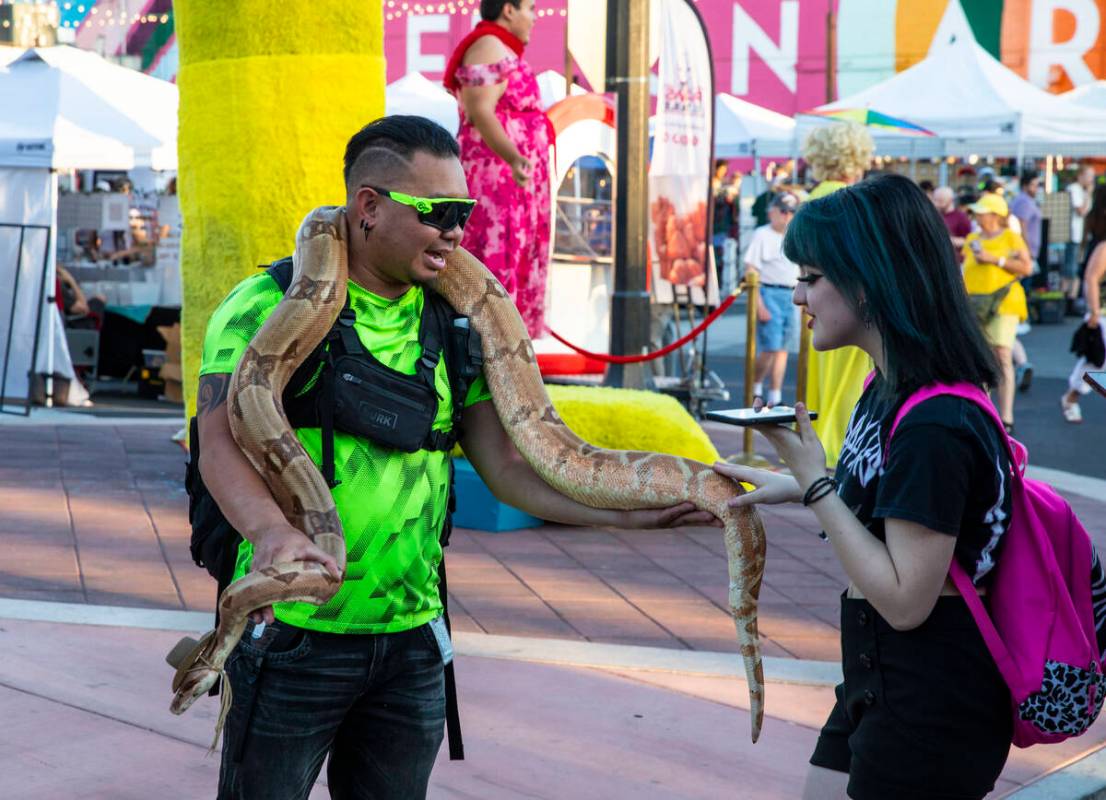 Josh Gamboa, left, lets Sophie Papadopoulos pet Salmon, his Columbian red tail boa, at the Firs ...