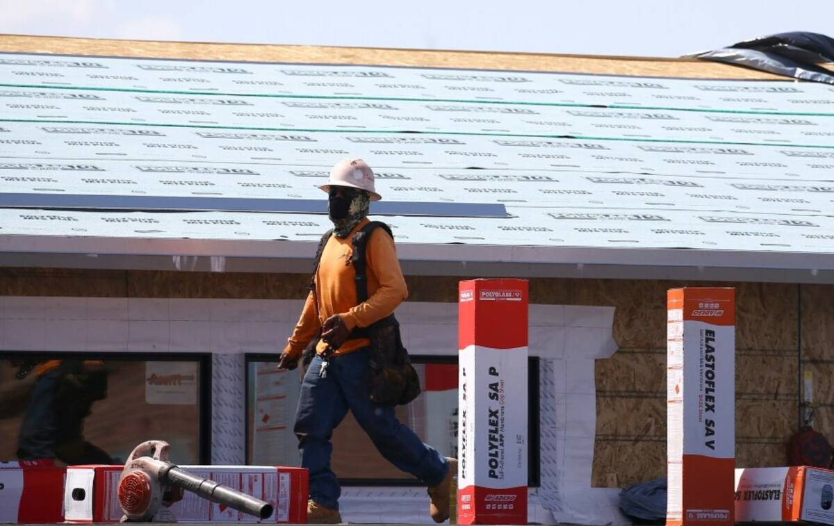 A construction worker continues building at a large housing development, April 21, 2020, in Pho ...