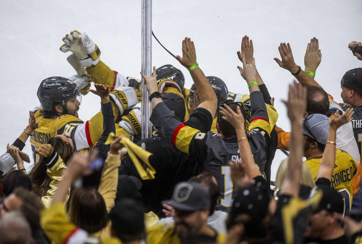 Golden Knights center Chandler Stephenson (20) celebrates a goal with teammates and fans during ...