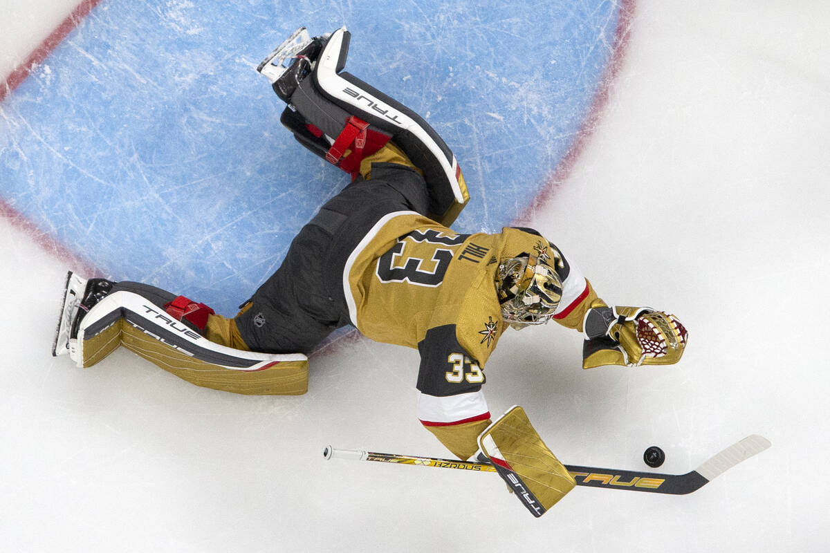 Golden Knights goaltender Adin Hill (33) dives to save the puck during the third period in Game ...