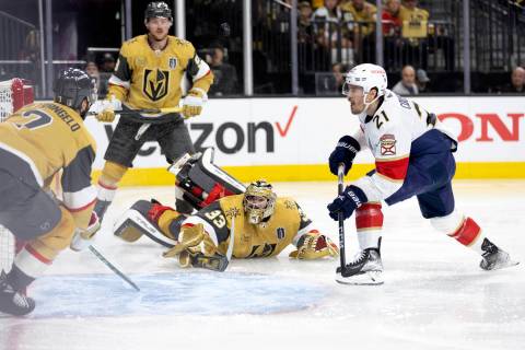 The puck is airborne after Golden Knights goaltender Adin Hill (33) saved it while Knights defe ...