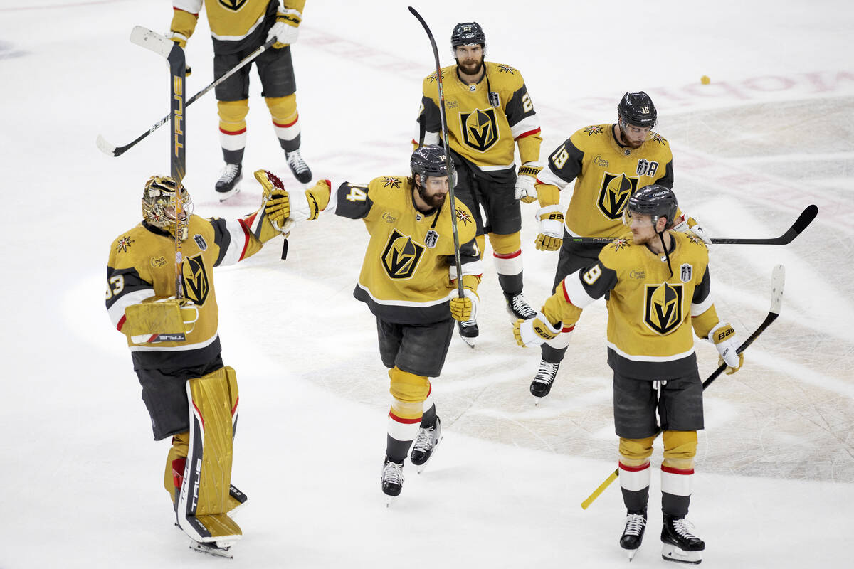 Golden Knights defenseman Nicolas Hague (14) slaps hands with goaltender Adin Hill (33) after t ...