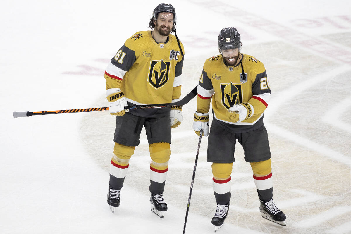 Golden Knights right wing Mark Stone (61) and center Chandler Stephenson (20) smile while skati ...