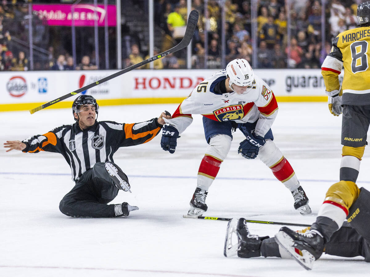 An official slips and a stick goes flying while attempting to restrain Florida Panthers center ...