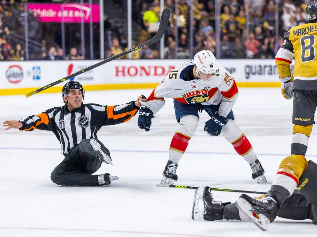 An official slips and a stick goes flying while attempting to restrain Florida Panthers center ...