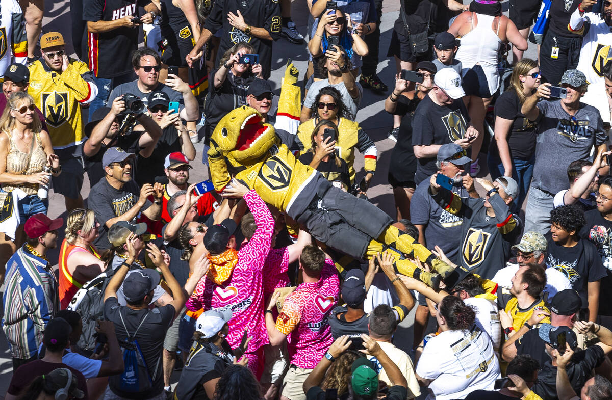 Golden Knights mascot Chance, the Gila monster, crowd surfs amongst fans about the stage in Tos ...