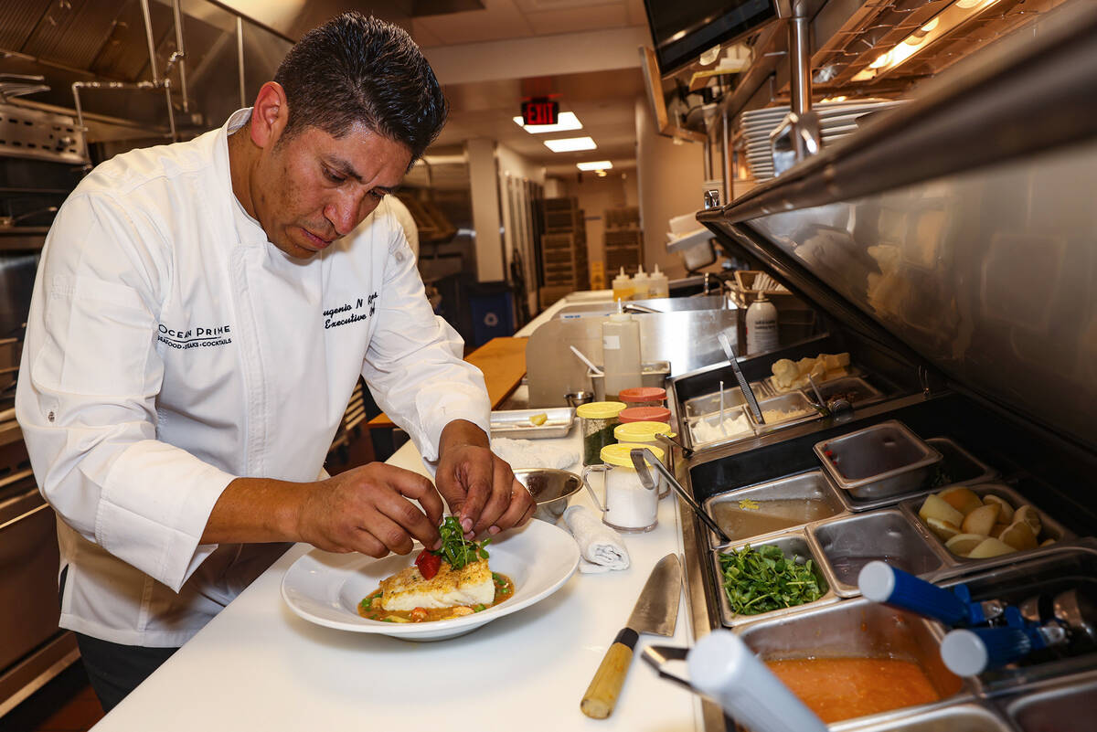 Executive Chef Eugenio Reyes plates the Alaskan Halibut at Ocean Prime, an upscale seafood and ...