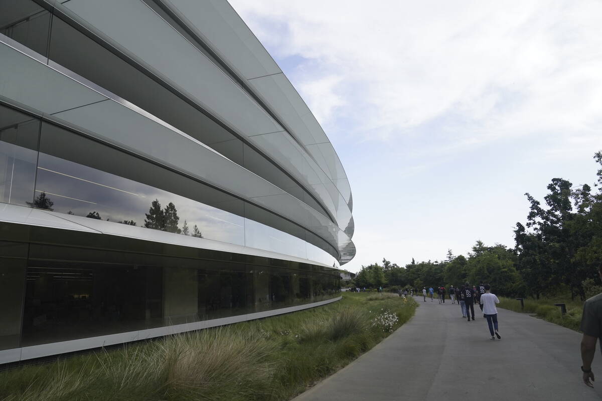 People walk along a paved path Monday, June 5, 2023, before an announcement on new products on ...