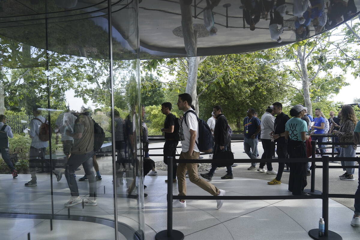 People are reflected as they enter a building Monday, June 5, 2023, before an announcement on n ...