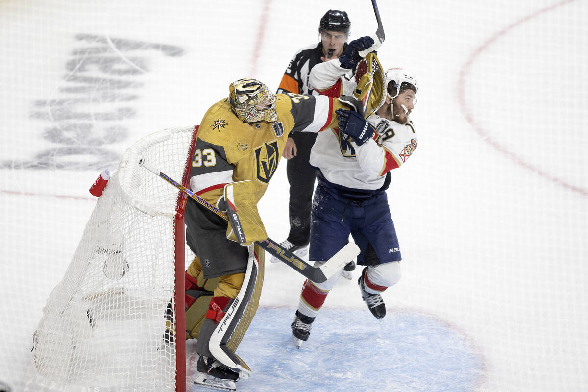 Golden Knights goaltender Adin Hill (33) pushes Florida Panthers left wing Matthew Tkachuk (19) ...