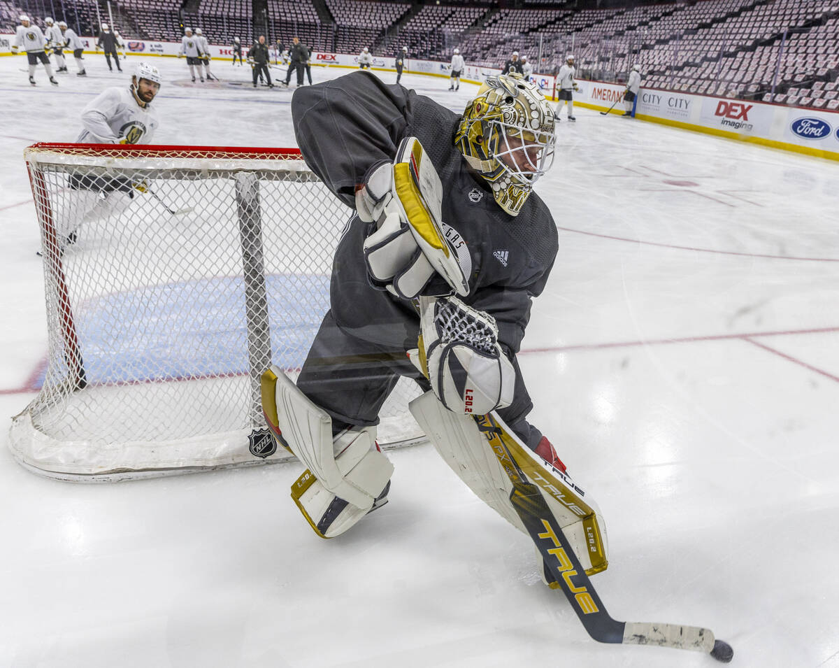 Golden Knights goaltender Adin Hill (33) slaps at a puck during an early skate before Game 3 of ...