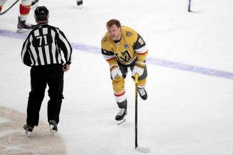 Golden Knights center Jack Eichel (9) skates off the ice from a scrum while grimacing during th ...