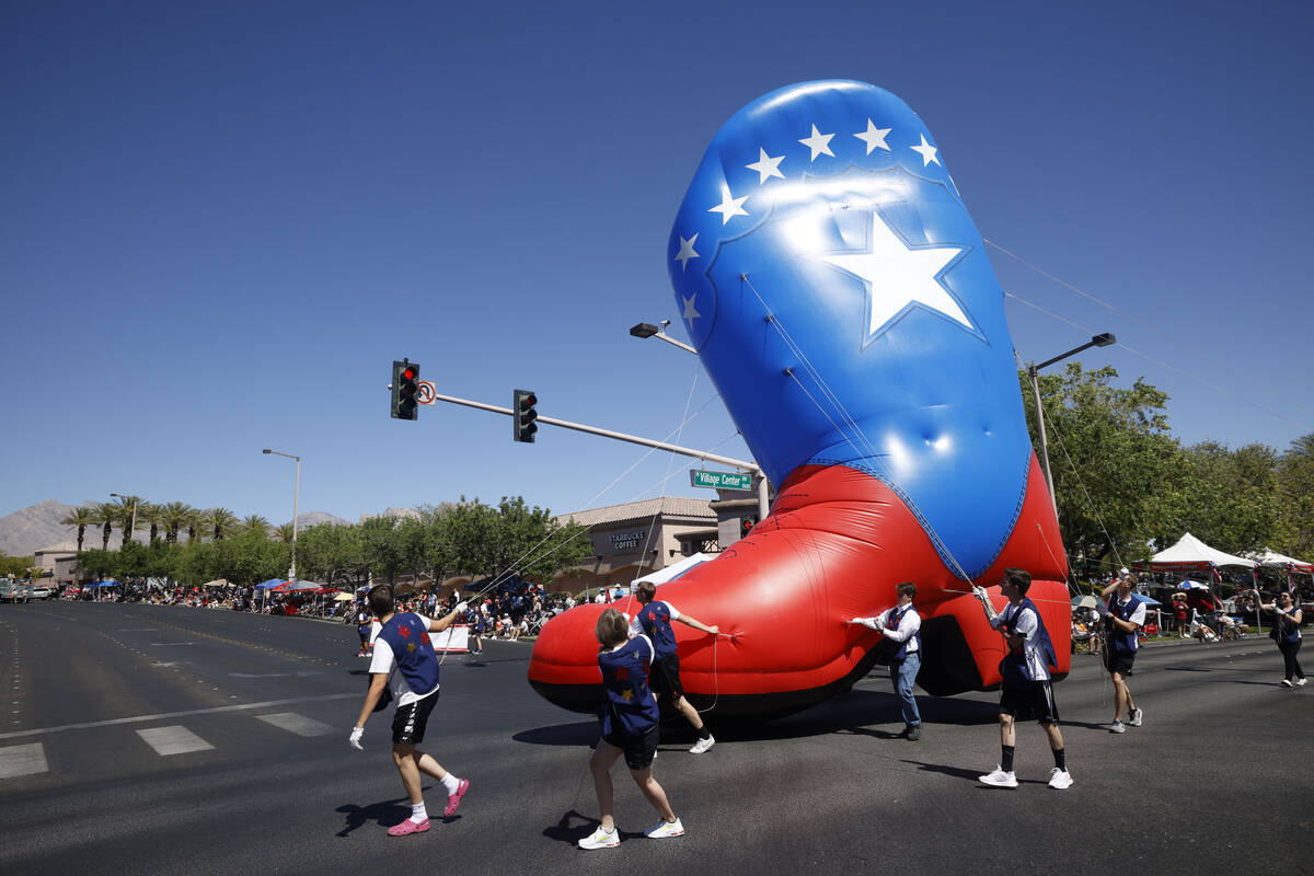 People carry a large inflatable balloon during the 28th annual Summerlin Council Patriotic Para ...