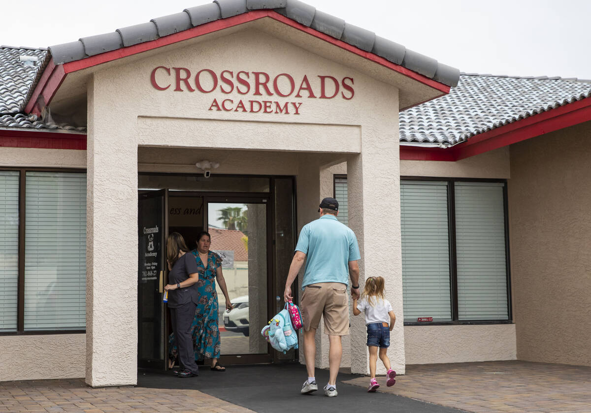Children are dropped off by their families at the Crossroads Academy preschool on Wednesday, Ju ...