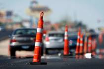 FILE - Heat rising from the pavement distorts the images of cars as they drive through road con ...