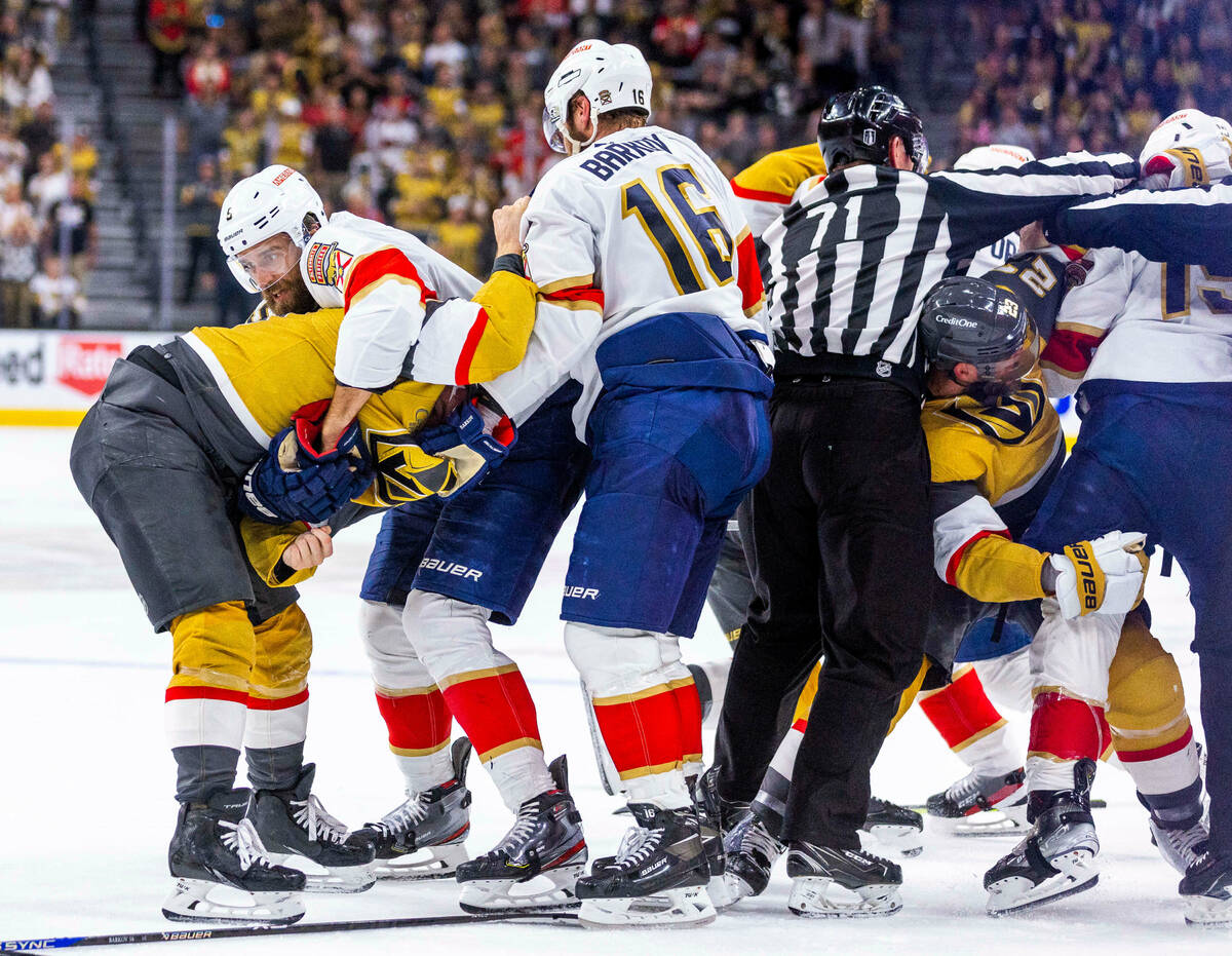 Golden Knights center Ivan Barbashev (49) is wrapped up by Florida Panthers defenseman Aaron Ek ...