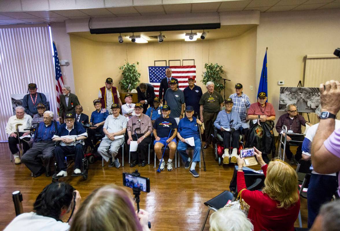 World War II veterans pose for a photo after a ceremony commemorating the 75th anniversary of t ...
