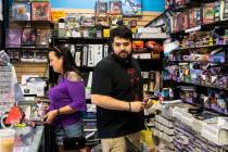 Andrew Soborski, manager, and Kelli Brown, owner, organize comics at Action Comics and Games al ...