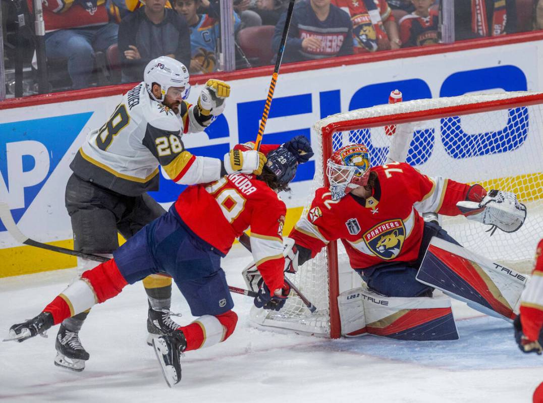 Golden Knights left wing William Carrier (28) checks Florida Panthers defenseman Josh Mahura (2 ...