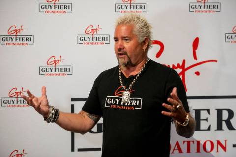 Chef and TV personality Guy Fieri talks to the media during an event honoring veterans and firs ...