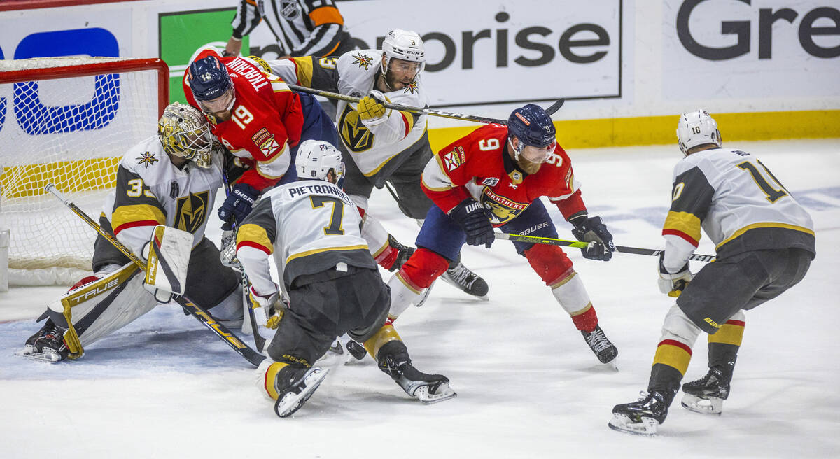 Golden Knights goaltender Adin Hill (33) is crashed into by Florida Panthers left wing Matthew ...