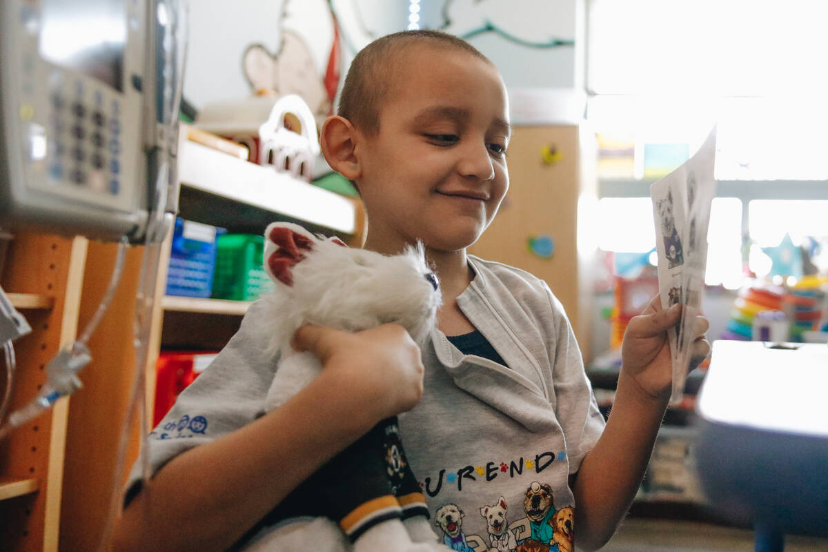 Alex Gonzalez, 7, looks at a sticker page he was given by Rick Williams, the owner of Deke Henr ...