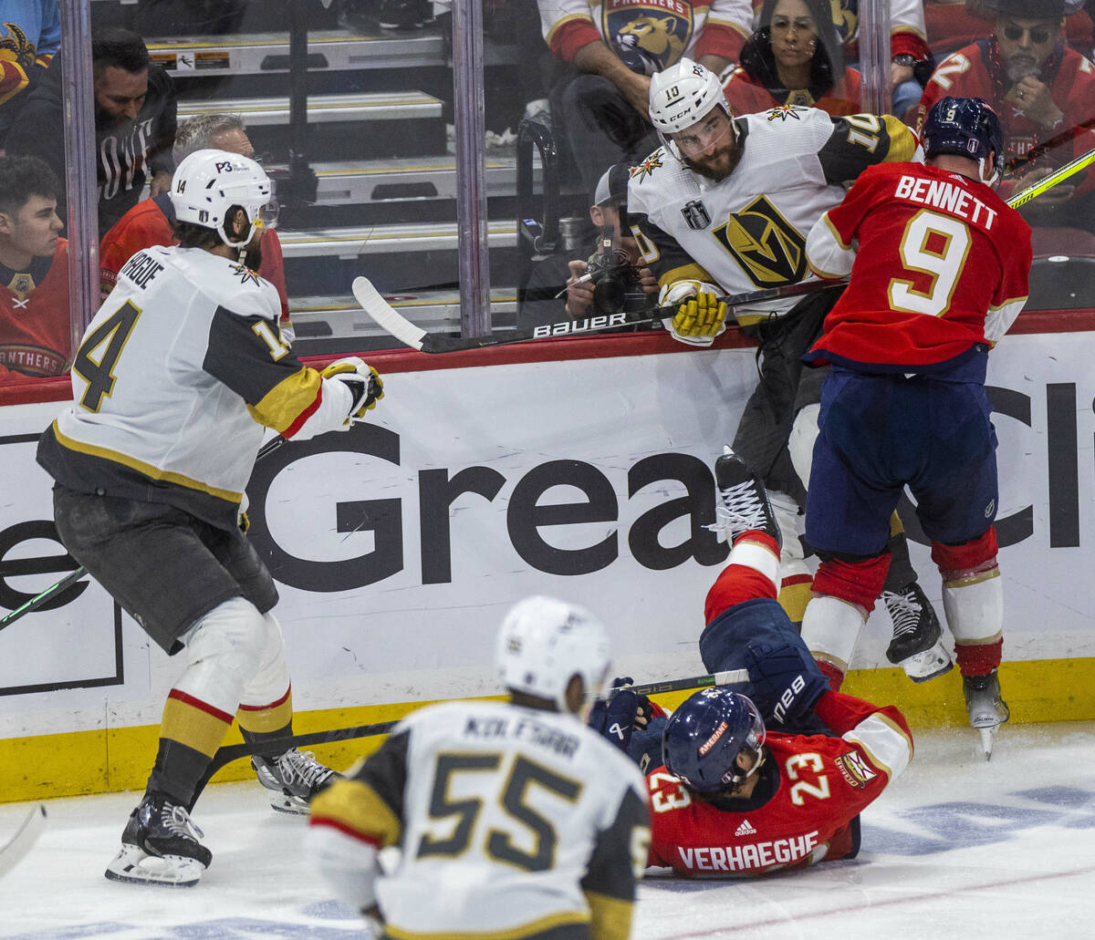 Golden Knights center Nicolas Roy (10) is checked into the boards by Florida Panthers center Sa ...