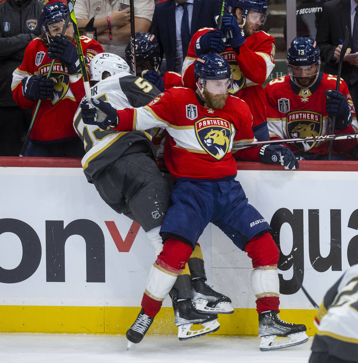 Golden Knights right wing Keegan Kolesar (55) is checked into the bench by Florida Panthers cen ...