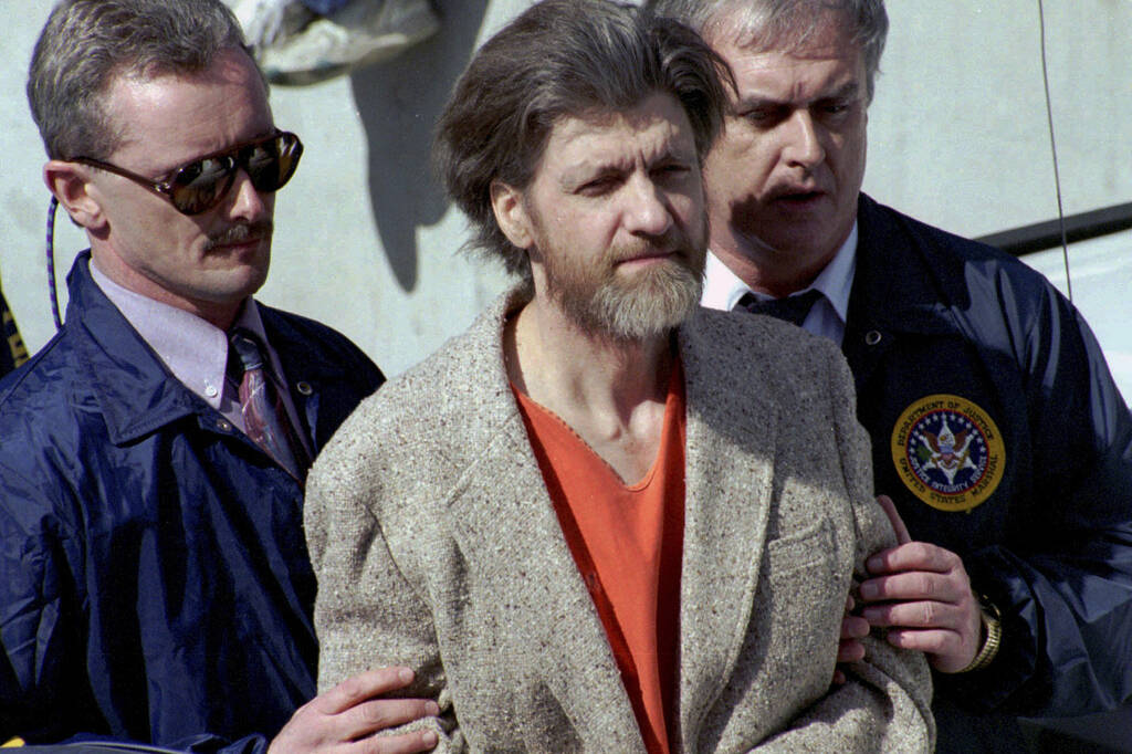 FILE - Theodore "Ted" Kaczynski is flanked by federal agents as he is led to a car fr ...