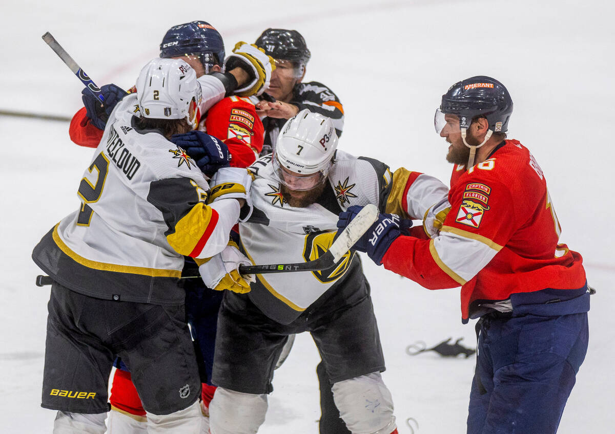Golden Knights defenseman Zach Whitecloud (2) tangles with Florida Panthers left wing Matthew T ...