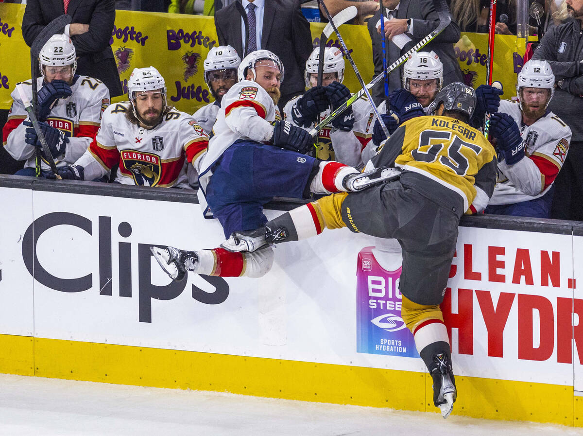 Florida Panthers defenseman Aaron Ekblad (5) is knocked into the bench by Golden Knights right ...