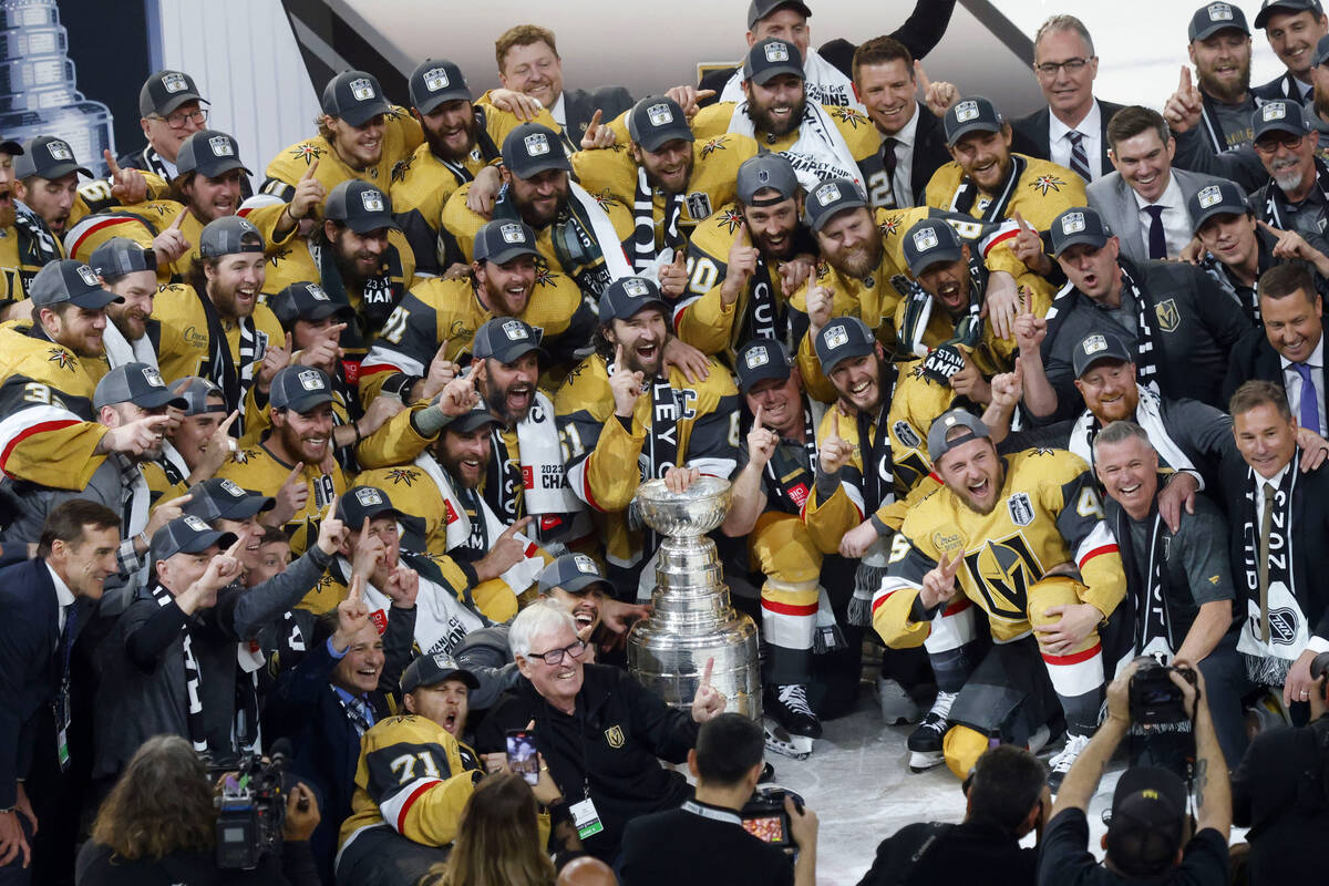 Golden Knights players pose for a photo with the Stanley Cup trophy after their victory against ...