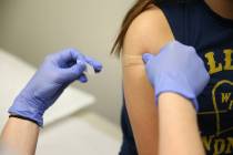 Natalia Ossa receives a vaccine from medical assistant Lindsey Johnson during a free back-to-sc ...