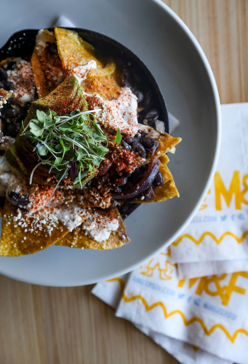 Chilaquiles, made with salsa verde, tortilla chips, folded egg, black beans, onion and jalapeñ ...