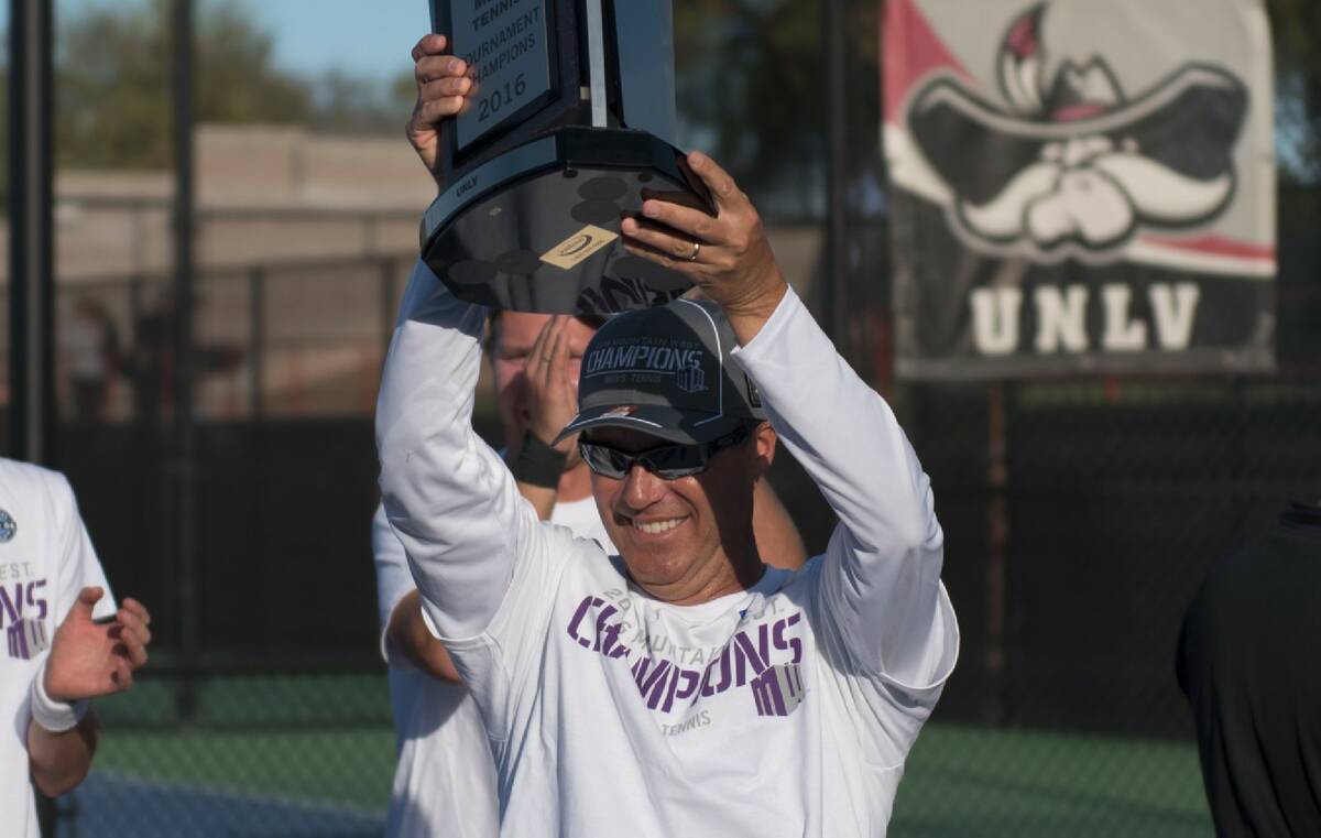 UNLV coach Owen Hambrook raises the Mountain West championship trophy at UNLV's Fertitta Tennis ...