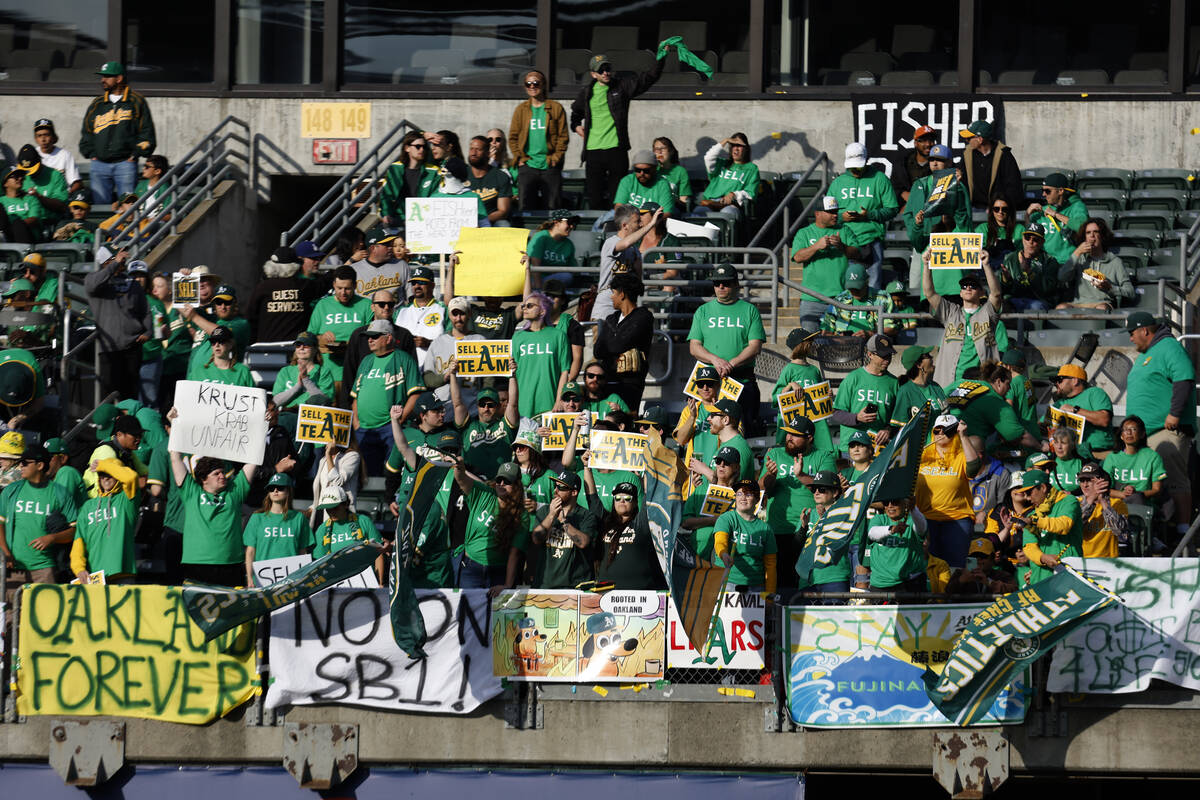 Fans hold signs at Oakland Coliseum to protest the Oakland Athletics' planned move to Las Vegas ...
