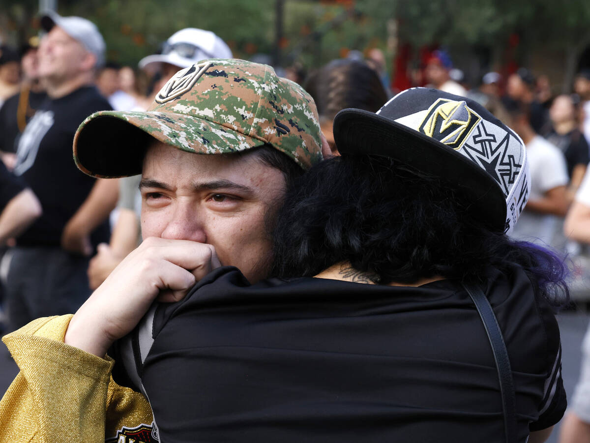 Golden Knights fans Andrew Hapitana, left, and his friend Valentina Astalas comfort each other ...
