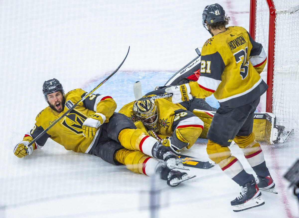 Golden Knights goaltender Adin Hill (33) makes another stop with assist from defenseman Brayden ...