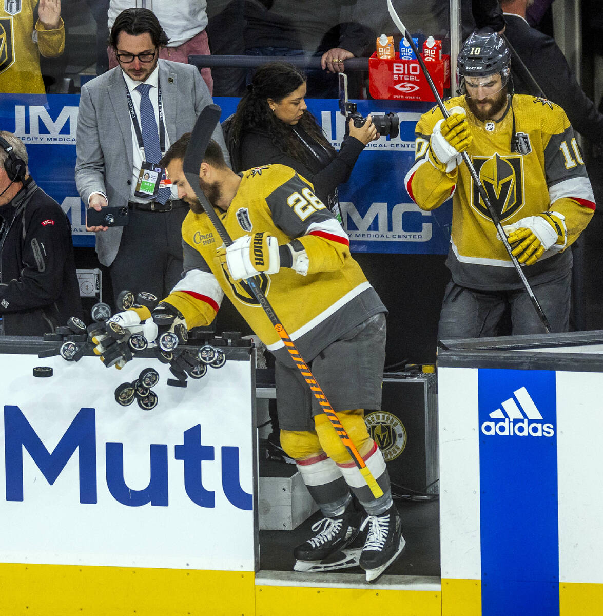 Golden Knights left wing William Carrier (28) knocks pucks off the bench rail for warmups befor ...