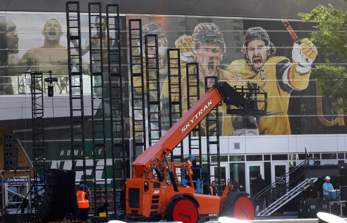 Workers set up the stage for the Stanley Cup victory parade and rally outside T-Mobile Arena on ...