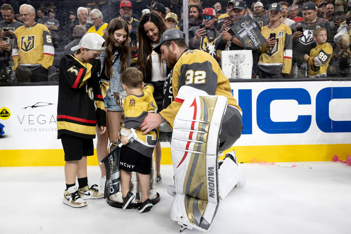 Golden Knights goaltender Jonathan Quick (32) wrangles his family for a photo with the Stanley ...