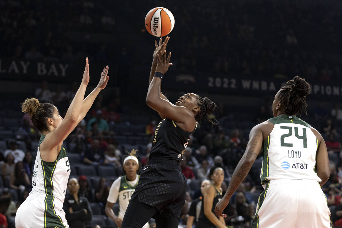 Las Vegas Aces guard Chelsea Gray (12) shoots against Seattle Storm guard Kia Nurse, left, and ...