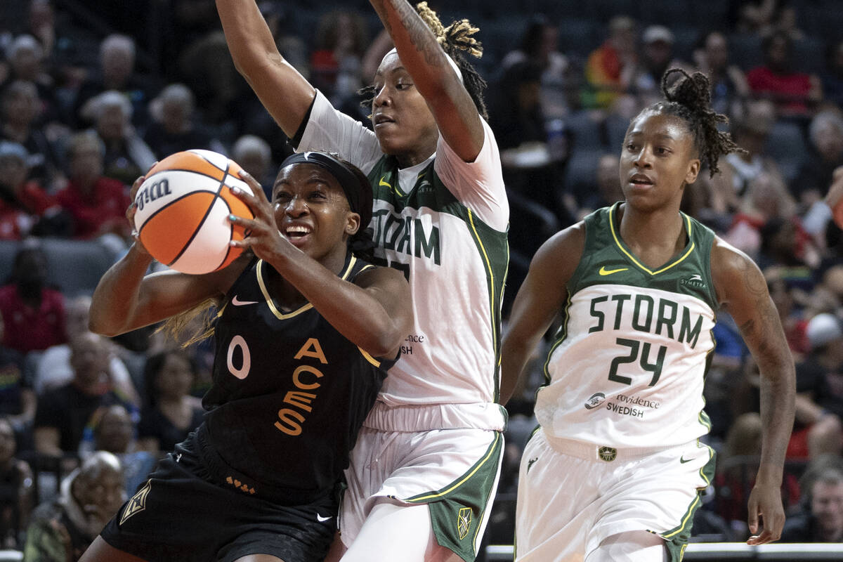 Las Vegas Aces guard Jackie Young (0) drives toward the hoop past Seattle Storm guard Yvonne Tu ...