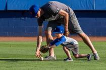 Dillon Truman, 4, races for the ball with his father Jared during father and child catch, an an ...