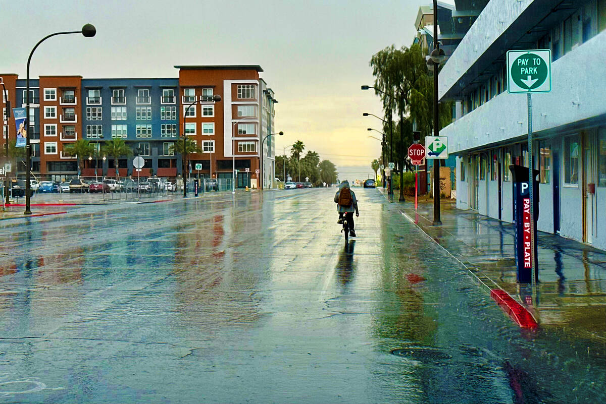 A man bicycles in the rain on East Carson Avenue on Friday, June 16, 2023, in Las Vegas. (LE Ba ...